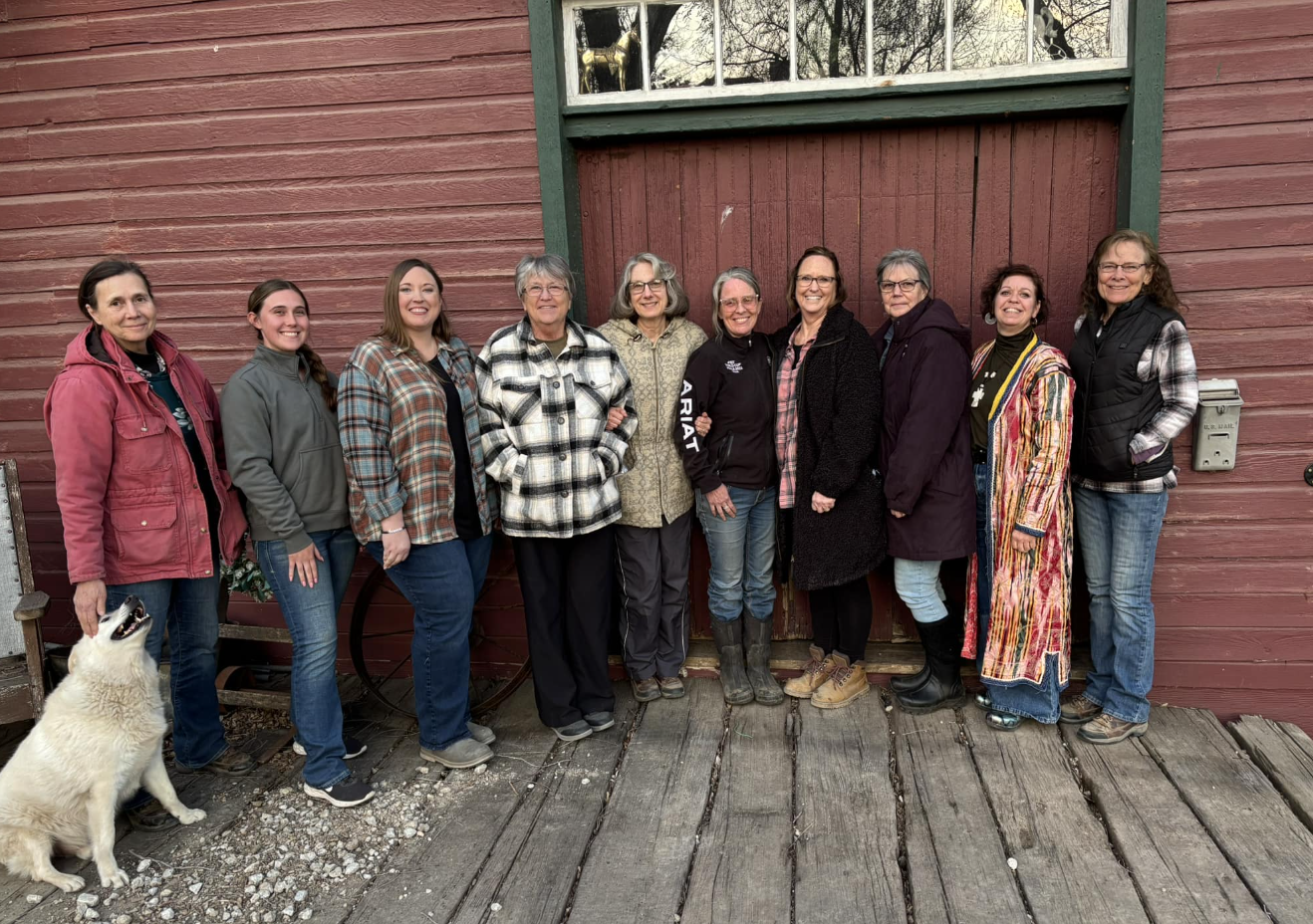 ladies standing in front of barn with dog, waiting to volunteer at S2S Ranch in Lincoln, NE